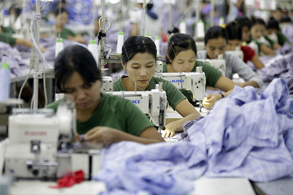 (140108) -- YANGON, Jan. 8, 2014 (Xinhua) -- People work at a garment factory of Hlaingtharyar Industrial Zone in Yangon, Myanmar, Jan. 8, 2014. During the government's planning commission in Nay Pyi Taw on Monday, Myanmar President U Thein Sein stressed the need to attract foreign investment to develop technology and human resources, and double domestic production in seven sectors in order to reach an 8-percent increase of the gross domestic product. (Xinhua/U Aung)